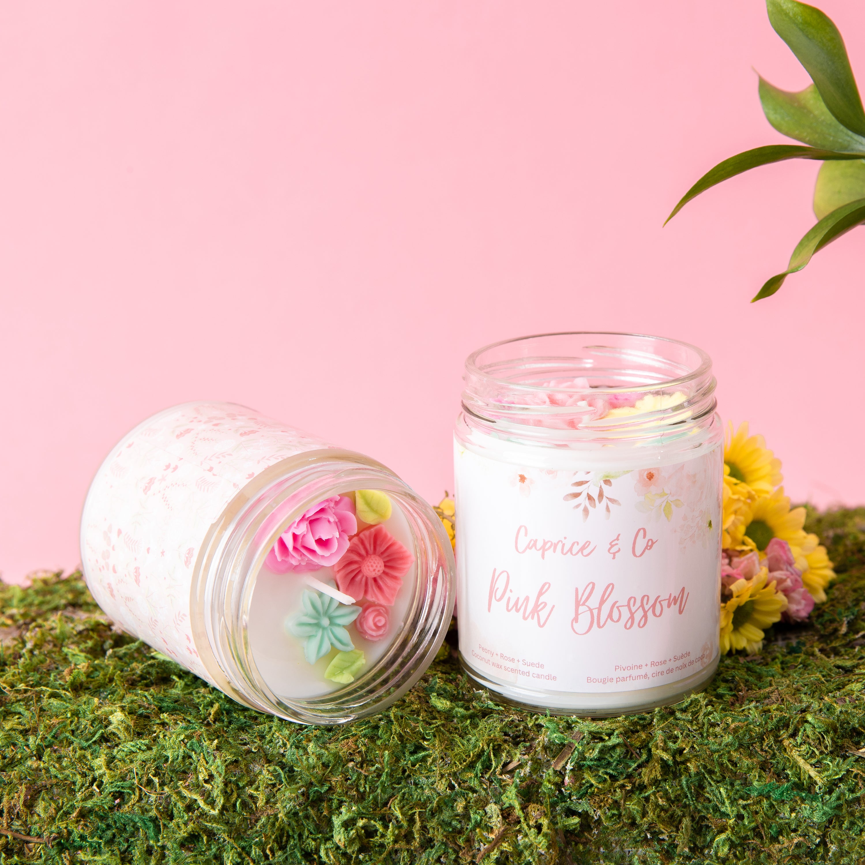 Pink Blossom Candle in a glass jar with a metal lid, featuring peony, rose, and suede scents.