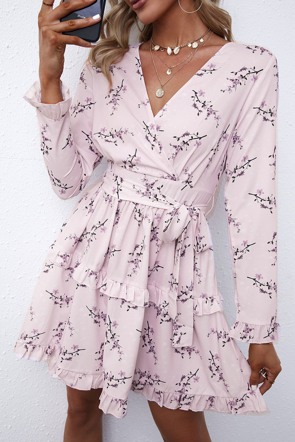 A stylish pink floral print mini dress featuring a ruffle hemline and wrap v neckline, perfect for casual and formal occasions.