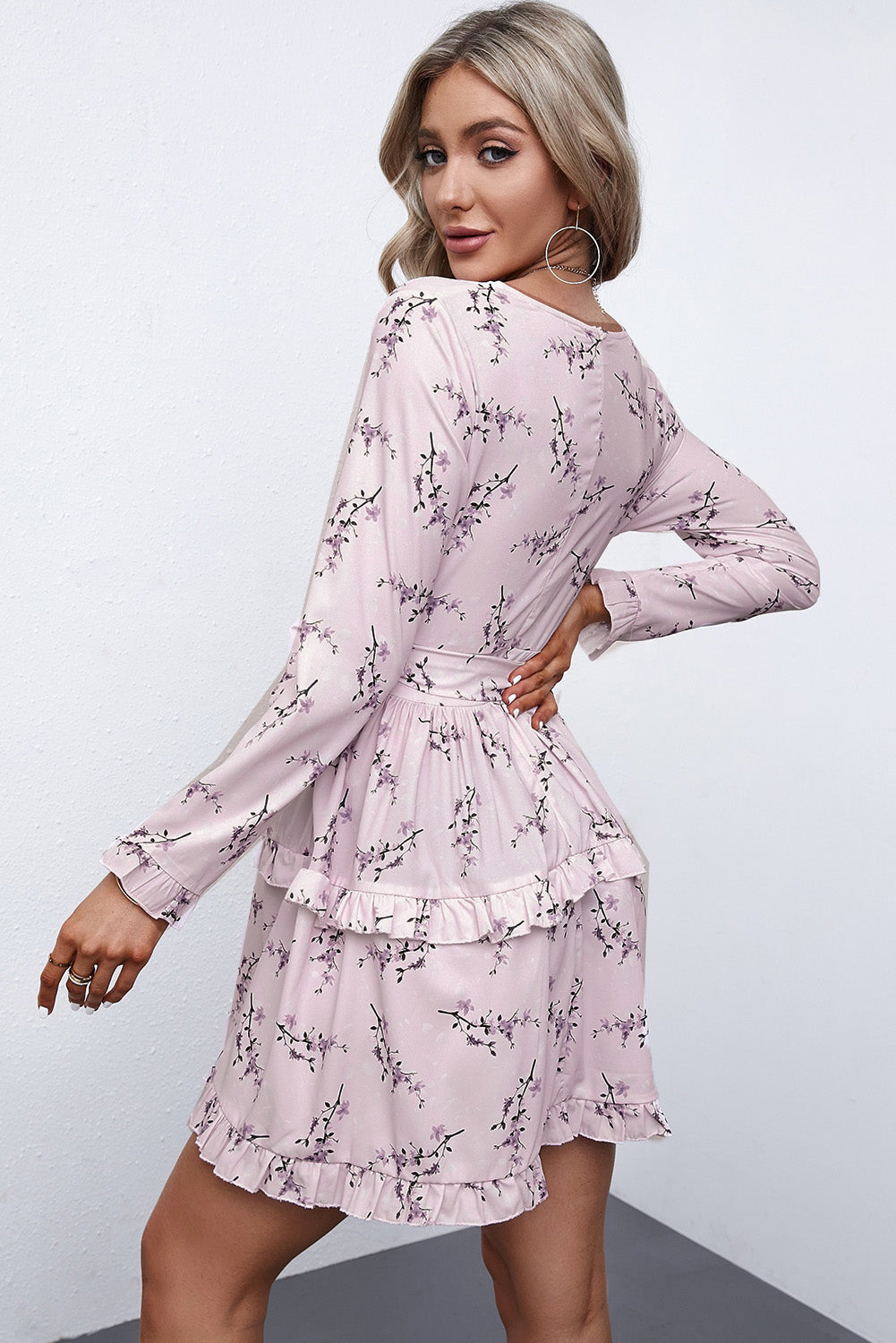 A stylish pink floral print mini dress featuring a ruffle hemline and wrap v neckline, perfect for casual and formal occasions.