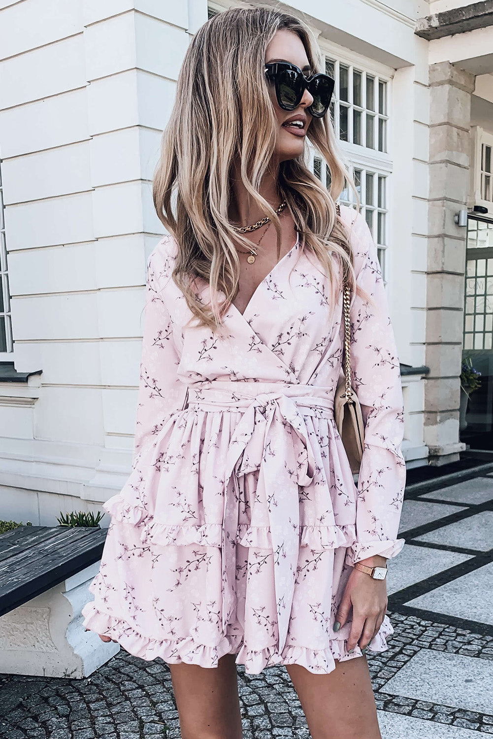 A stylish pink floral print mini dress featuring a ruffle hemline and wrap v neckline, perfect for casual and formal occasions.