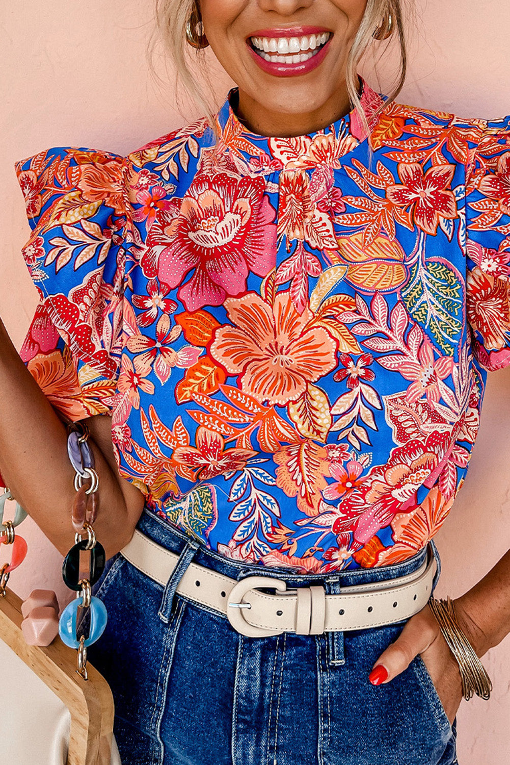 A stylish pink floral blouse featuring ruffled puff sleeves and a mock neck, perfect for casual or formal occasions.