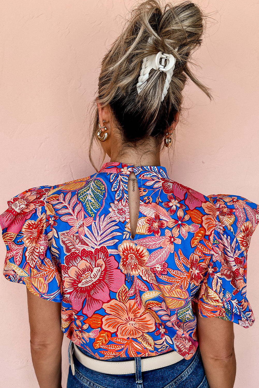 A stylish pink floral blouse featuring ruffled puff sleeves and a mock neck, perfect for casual or formal occasions.