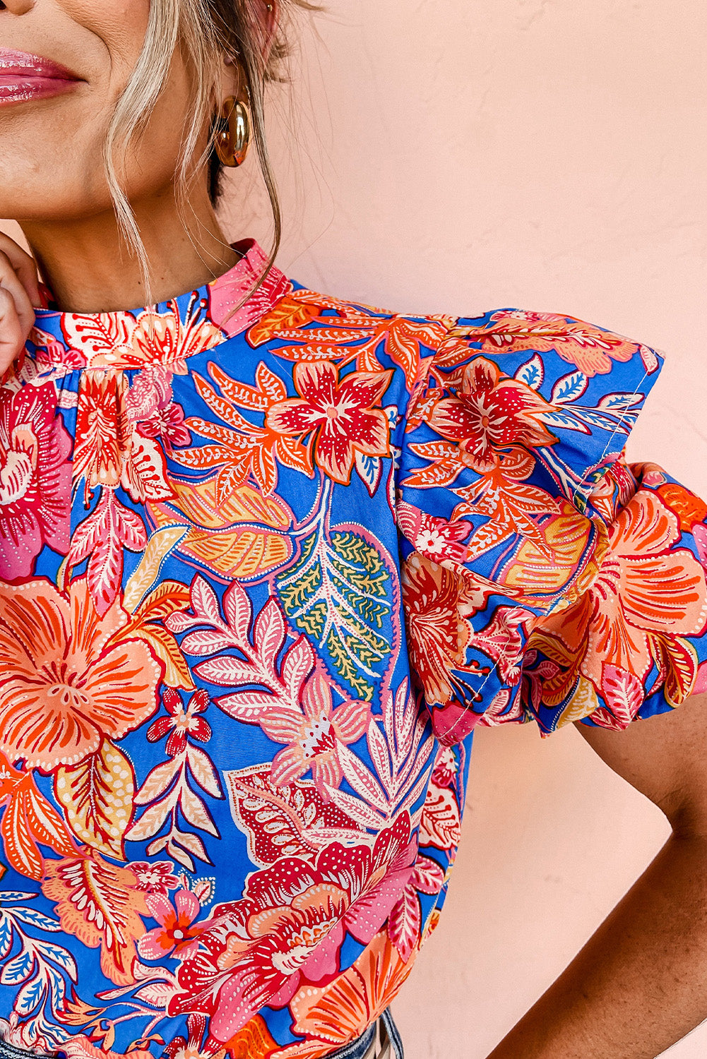 A stylish pink floral blouse featuring ruffled puff sleeves and a mock neck, perfect for casual or formal occasions.