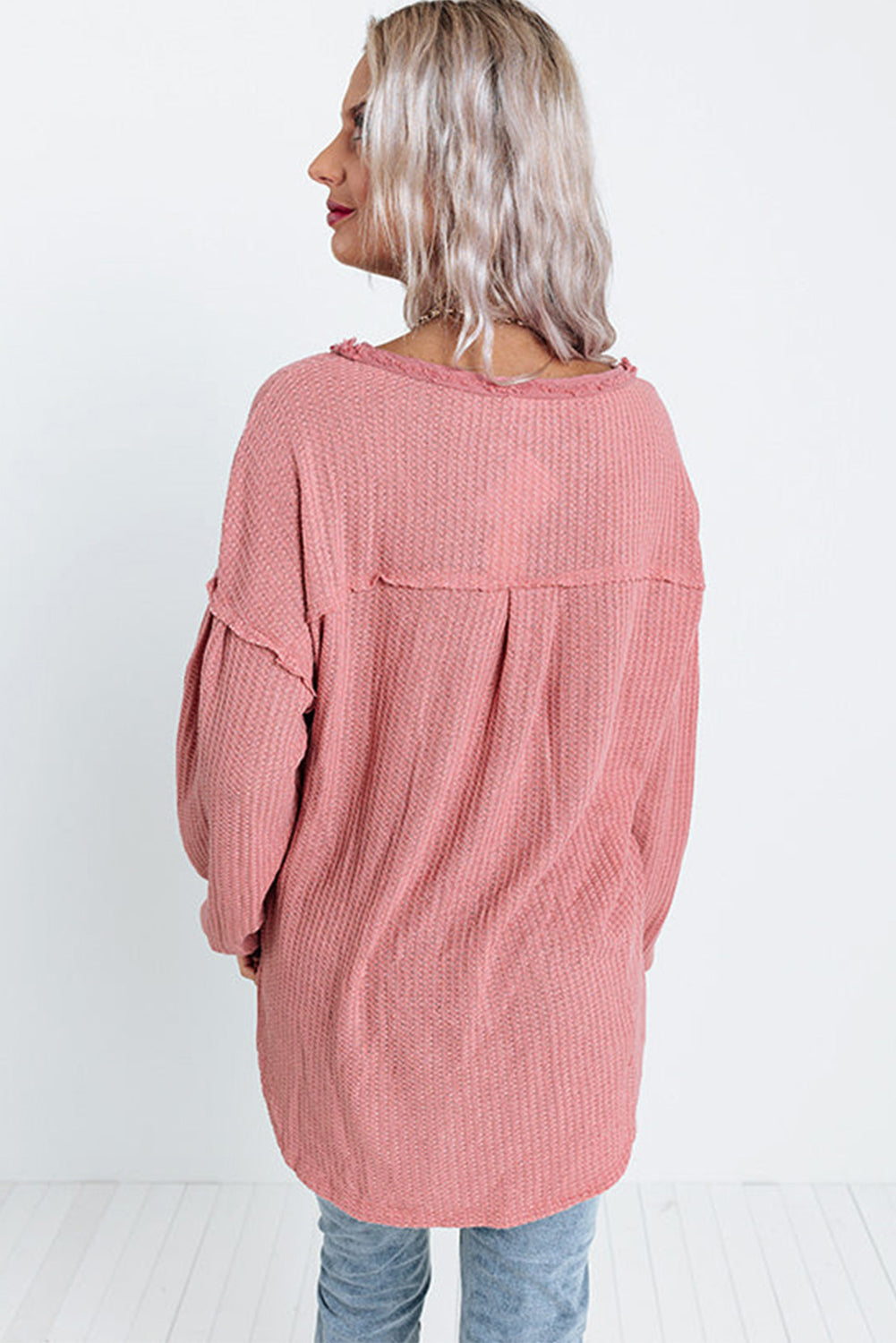 A stylish pink frayed patchwork waffle knit top featuring a buttoned neckline, drop shoulders, and a patch pocket, perfect for casual wear.