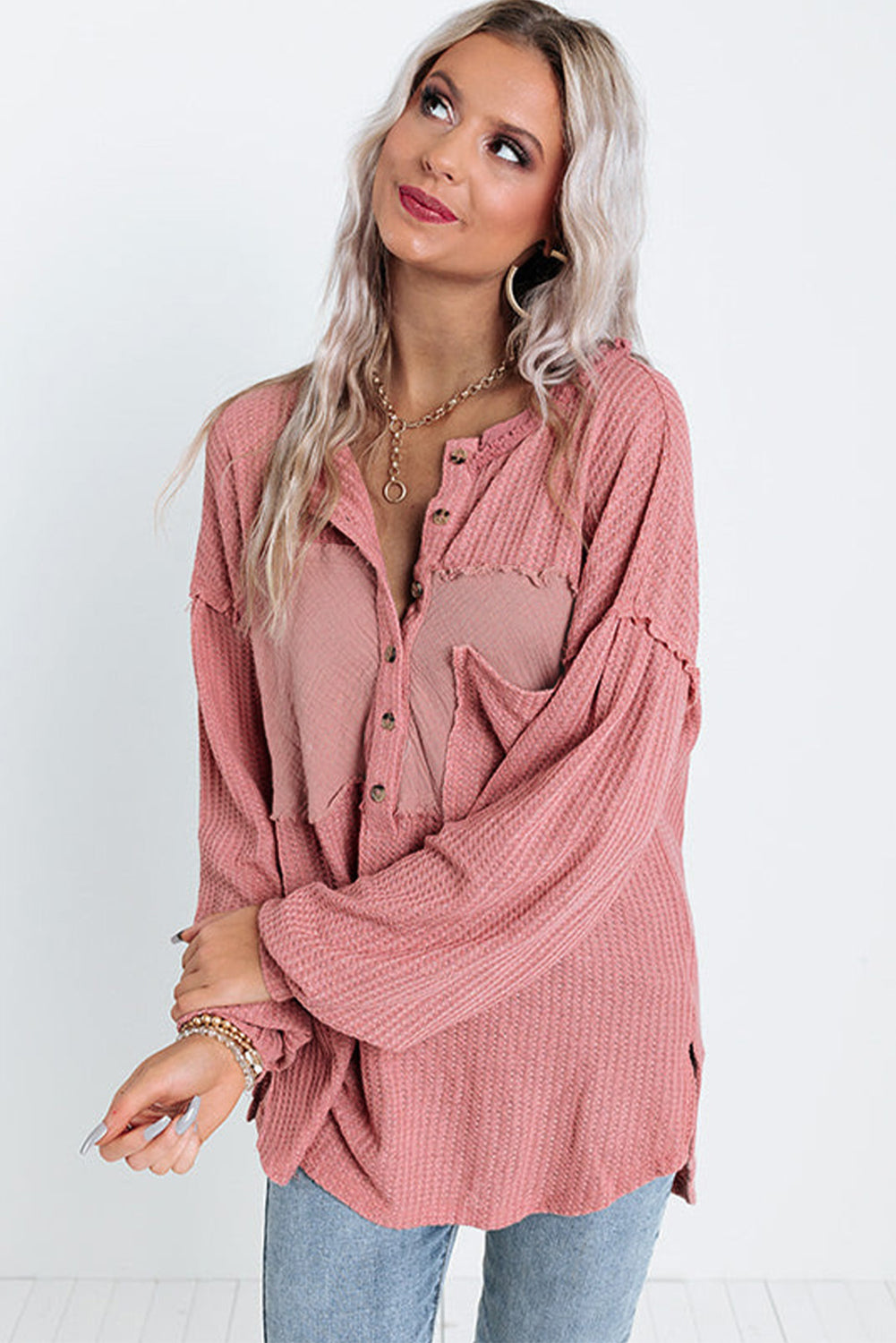 A stylish pink frayed patchwork waffle knit top featuring a buttoned neckline, drop shoulders, and a patch pocket, perfect for casual wear.