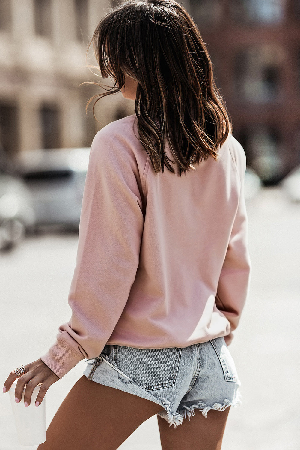 A stylish pink French terry cotton blend pullover sweatshirt featuring a crew neckline, long sleeves, and distressed detailing for a relaxed look.