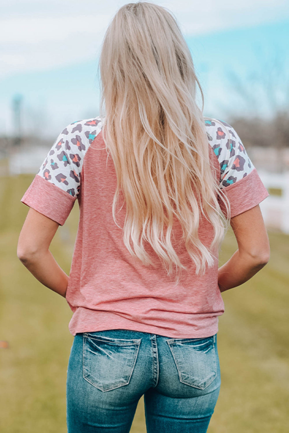 A stylish pink t-shirt featuring lace-up detail and leopard print raglan sleeves, perfect for casual wear.