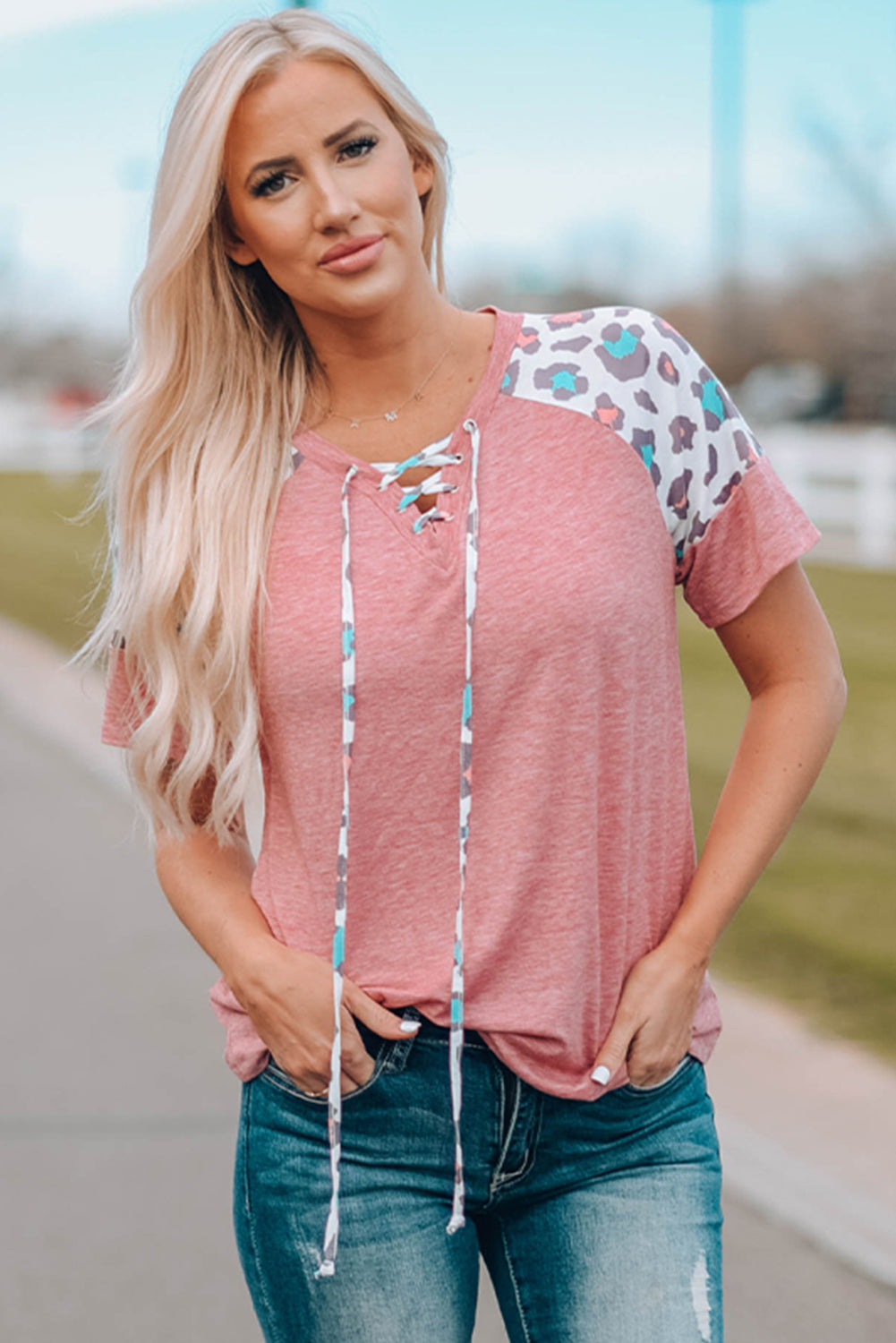 A stylish pink t-shirt featuring lace-up detail and leopard print raglan sleeves, perfect for casual wear.