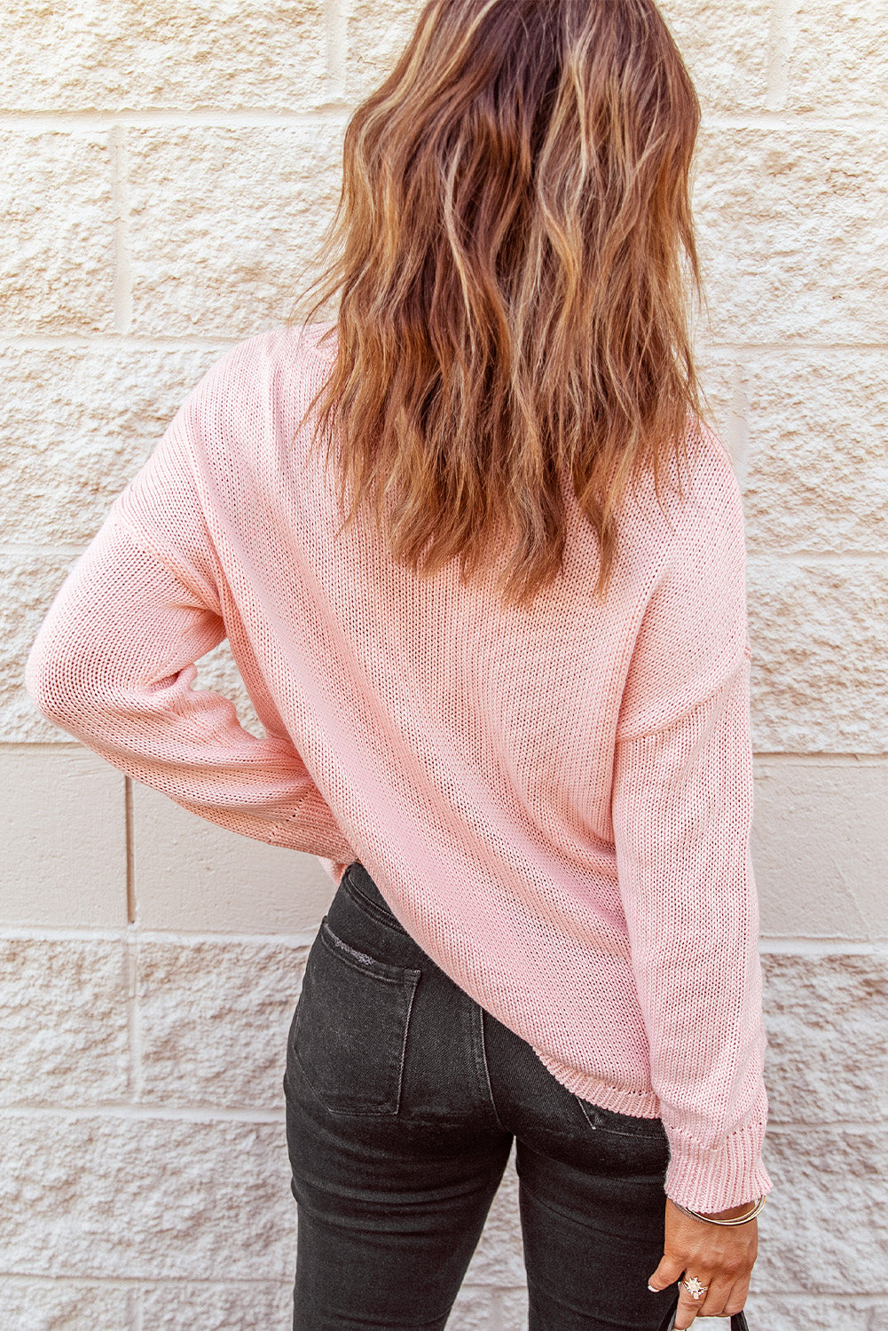 A stylish pink oversize knitted sweater with drop-shoulder sleeves, perfect for winter wear.