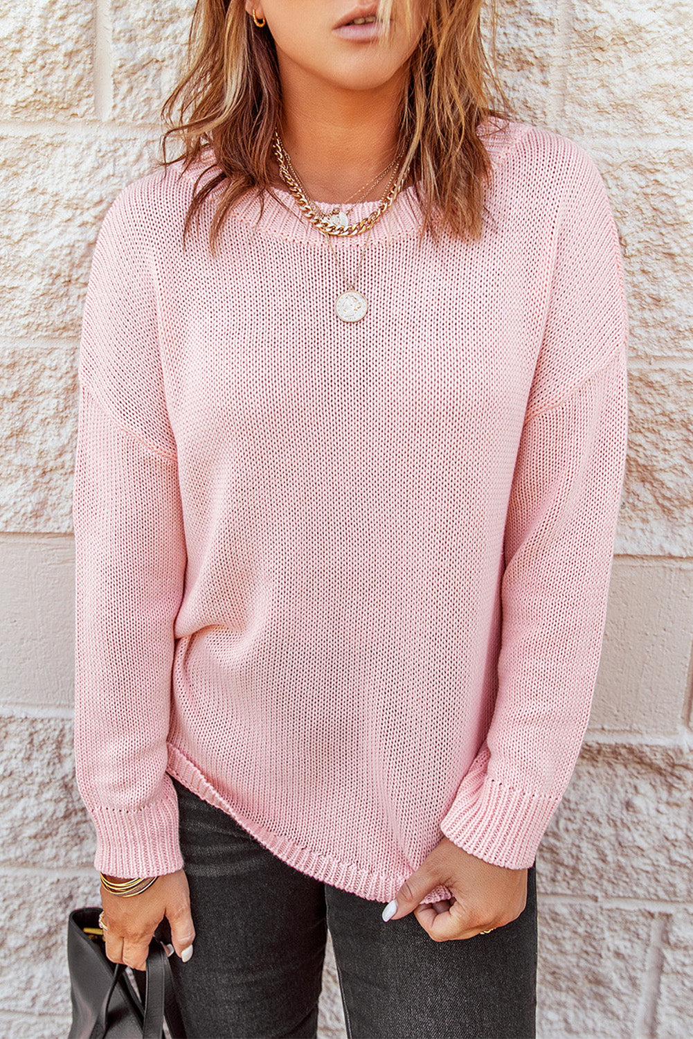 A stylish pink oversize knitted sweater with drop-shoulder sleeves, perfect for winter wear.