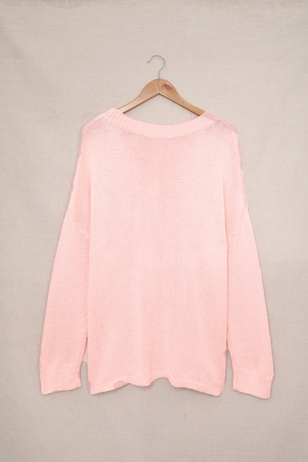 A stylish pink oversize knitted sweater with drop-shoulder sleeves, perfect for winter wear.