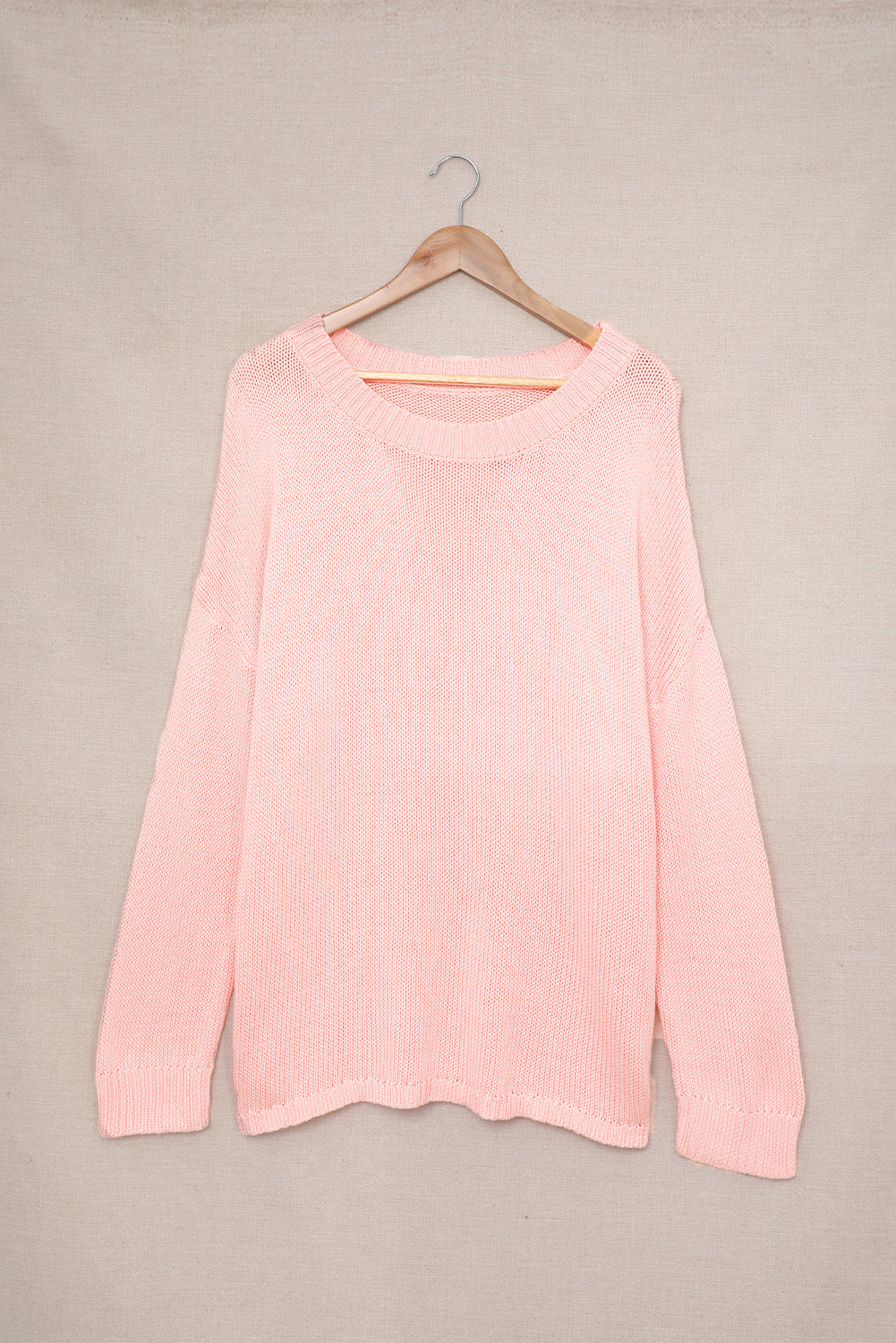 A stylish pink oversize knitted sweater with drop-shoulder sleeves, perfect for winter wear.