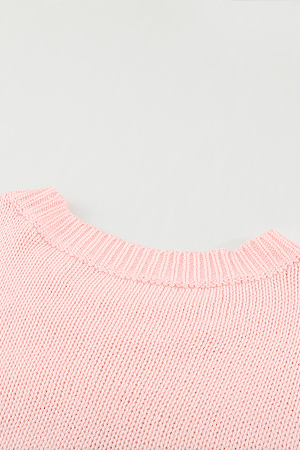 A stylish pink oversize knitted sweater with drop-shoulder sleeves, perfect for winter wear.