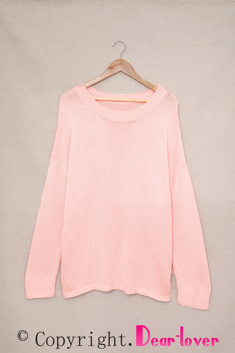 A stylish pink oversize knitted sweater with drop-shoulder sleeves, perfect for winter wear.