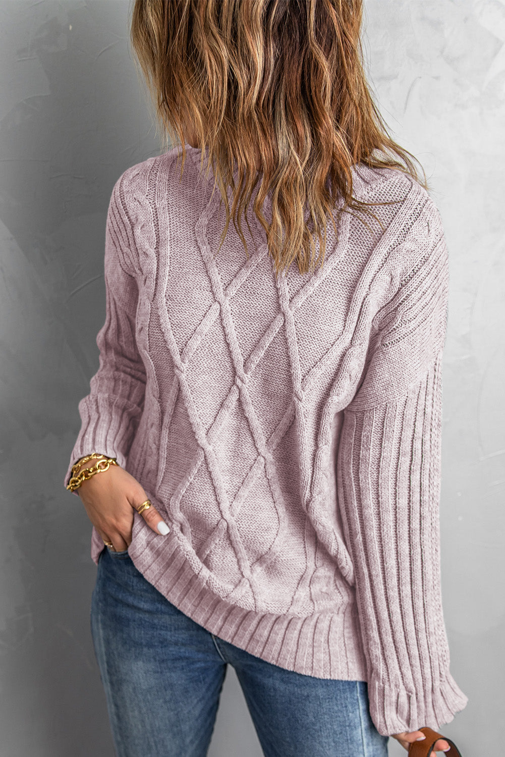 A cozy pink oversize thick pullover sweater with a cable knit design, perfect for winter wear.