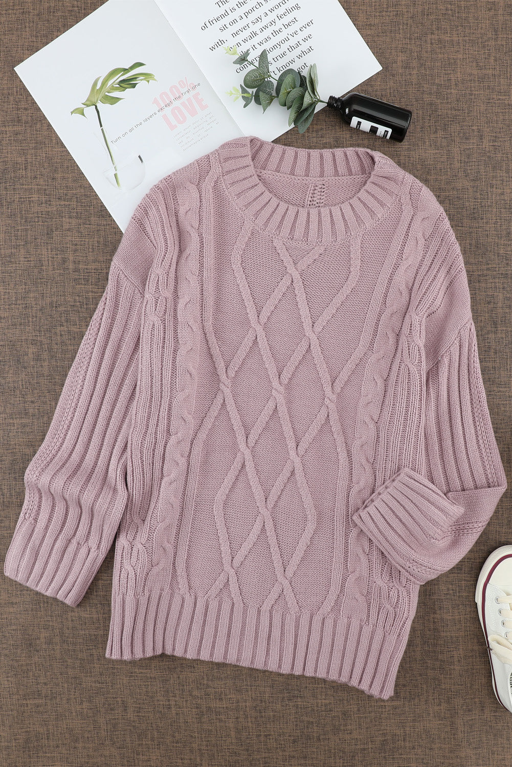 A cozy pink oversize thick pullover sweater with a cable knit design, perfect for winter wear.