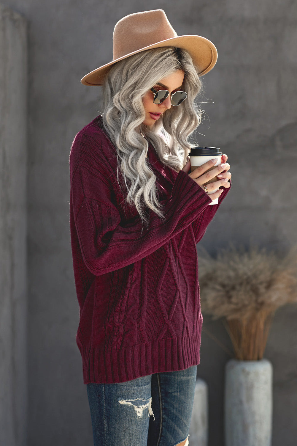 A cozy pink oversize thick pullover sweater with a cable knit design, perfect for winter wear.