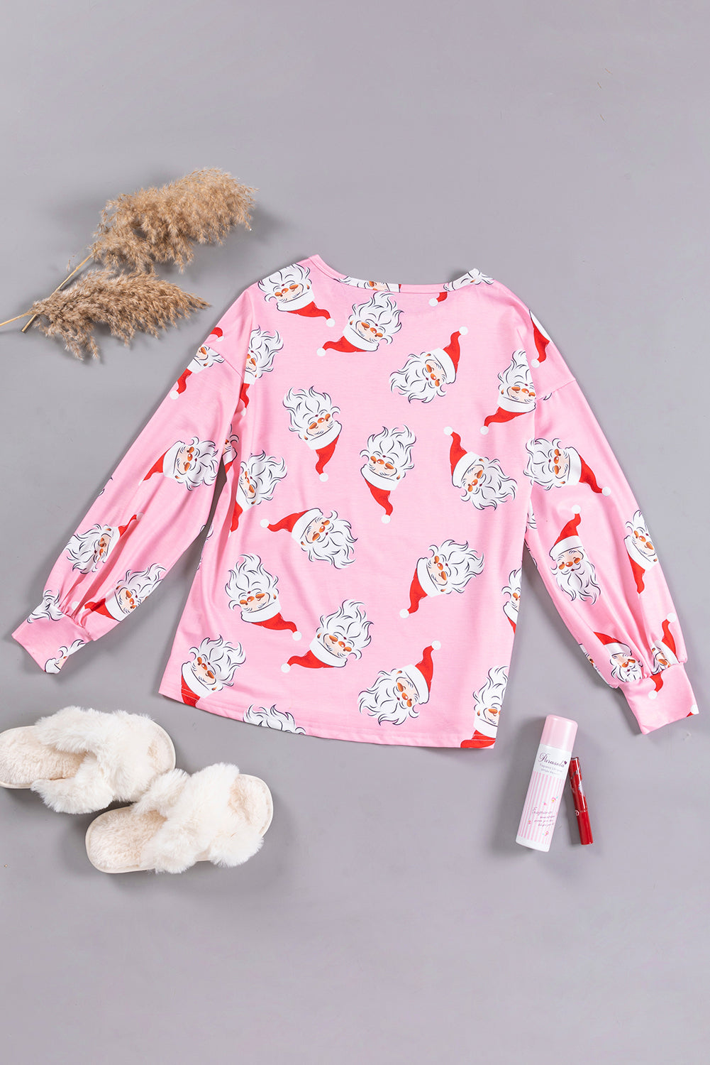 A stylish pink blouse featuring a festive Santa Claus print and elegant lantern sleeves, perfect for Christmas celebrations.