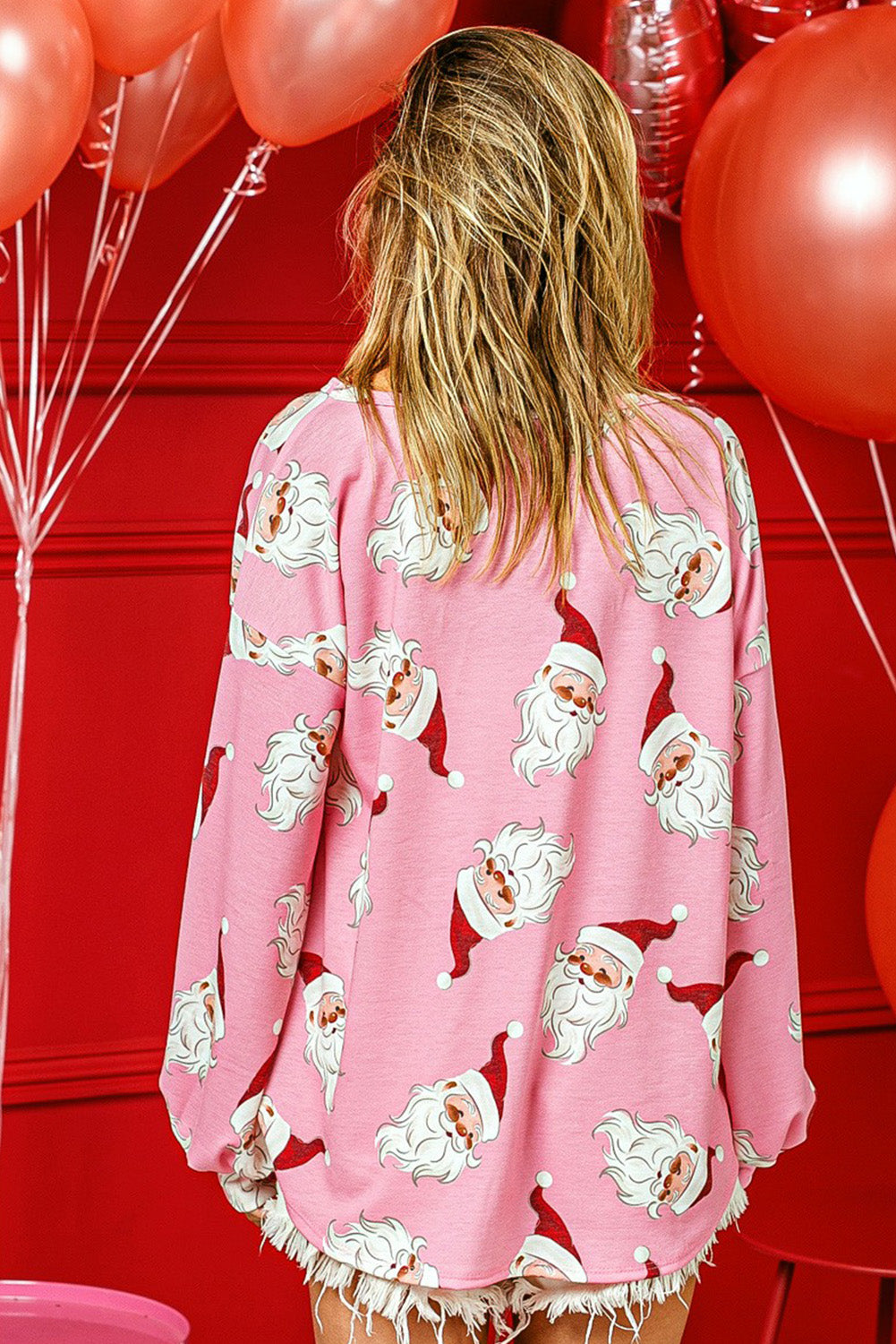 A stylish pink blouse featuring a festive Santa Claus print and elegant lantern sleeves, perfect for Christmas celebrations.