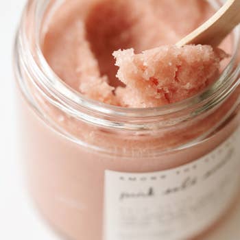 A 4 oz jar of Pink Salt Scrub with a cheerful grapefruit scent, showcasing its natural ingredients like pink salt and coconut oil.