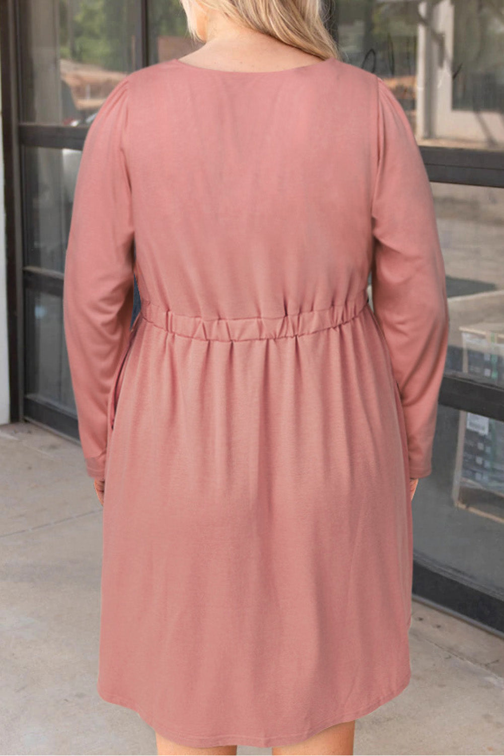 A stylish pink solid button front plus size long sleeve dress displayed on a mannequin, featuring a scoop neck and side pockets.