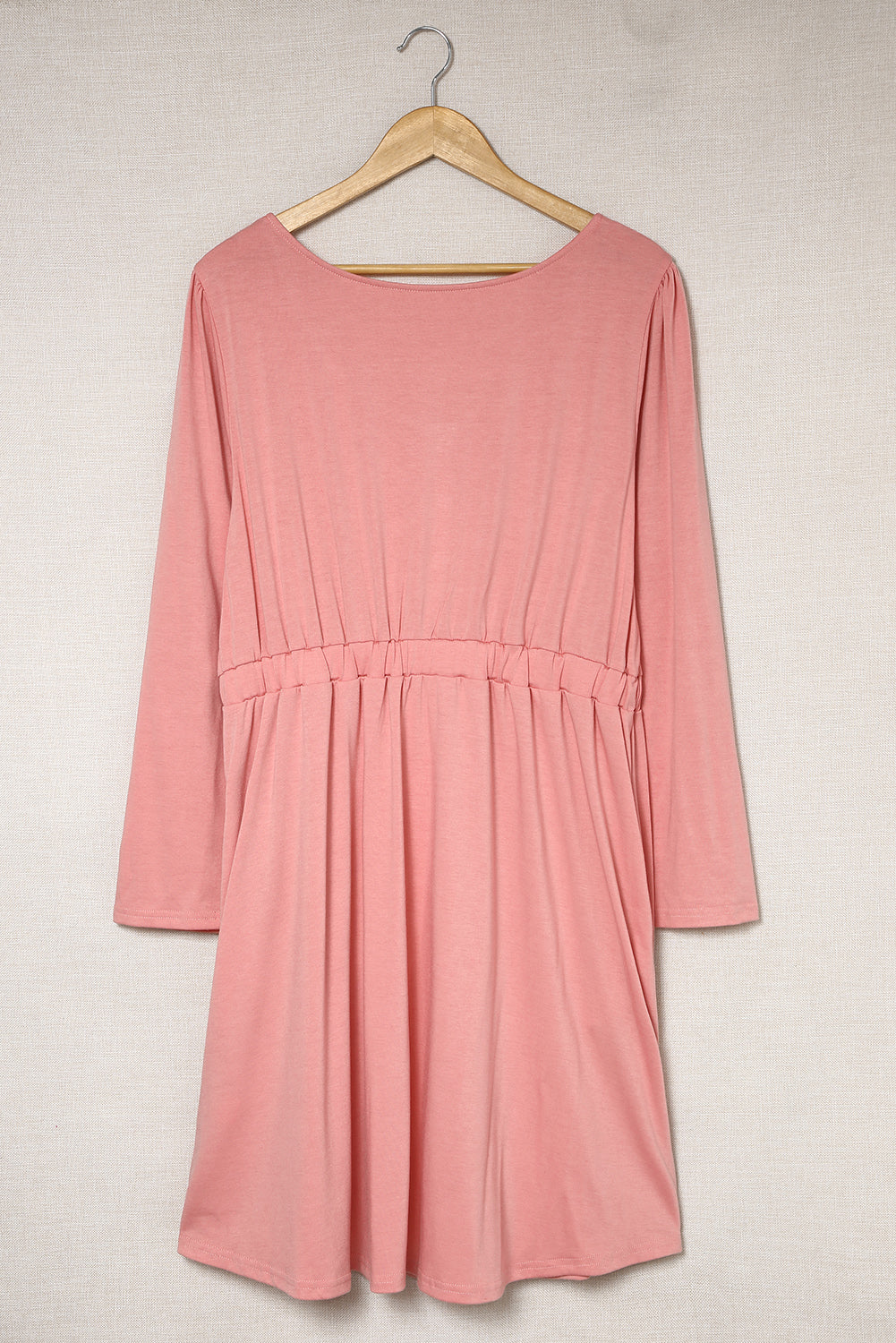 A stylish pink solid button front plus size long sleeve dress displayed on a mannequin, featuring a scoop neck and side pockets.