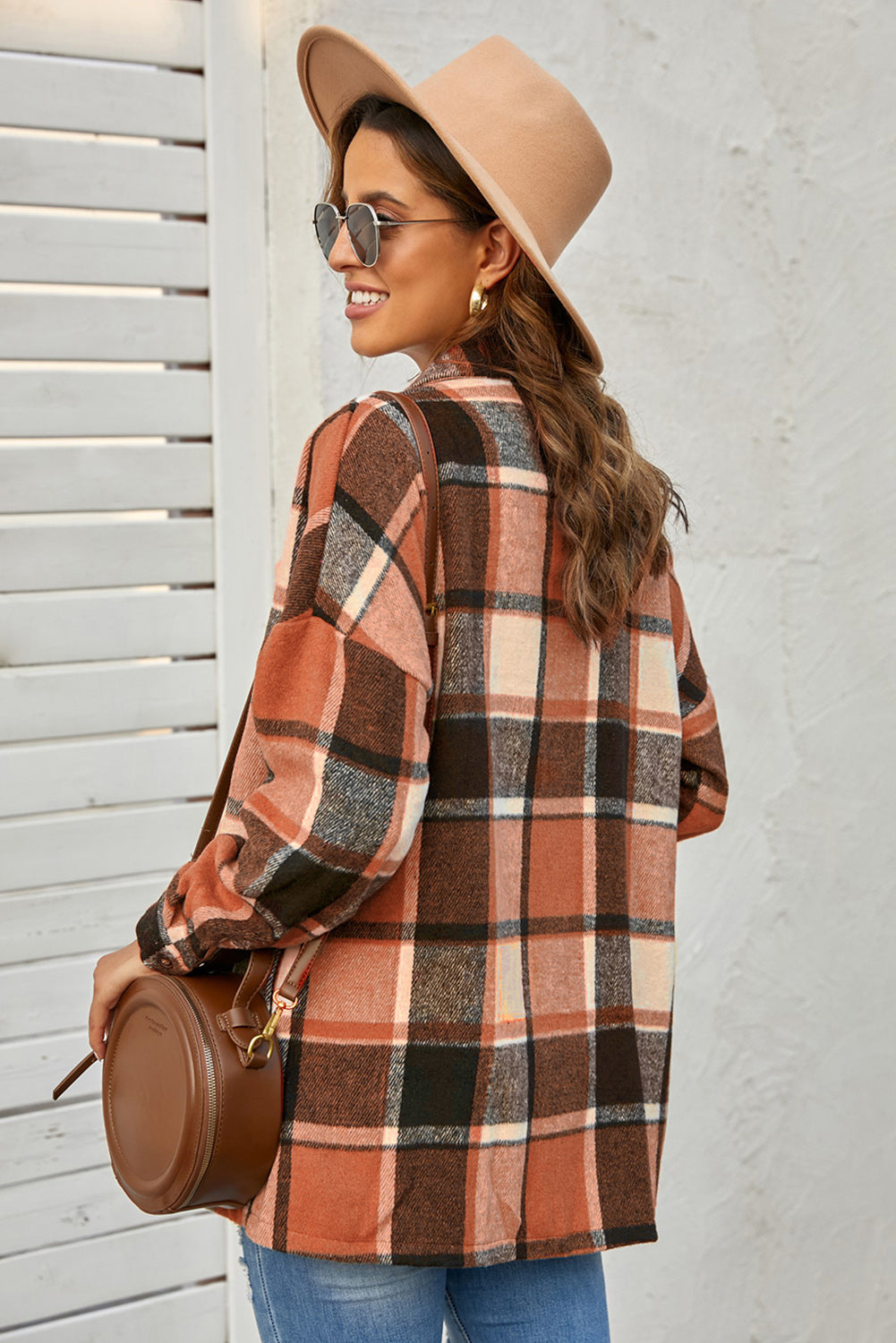 A stylish plaid print buttoned shirt jacket in warm tones, showcasing its soft fabric and button closure design.