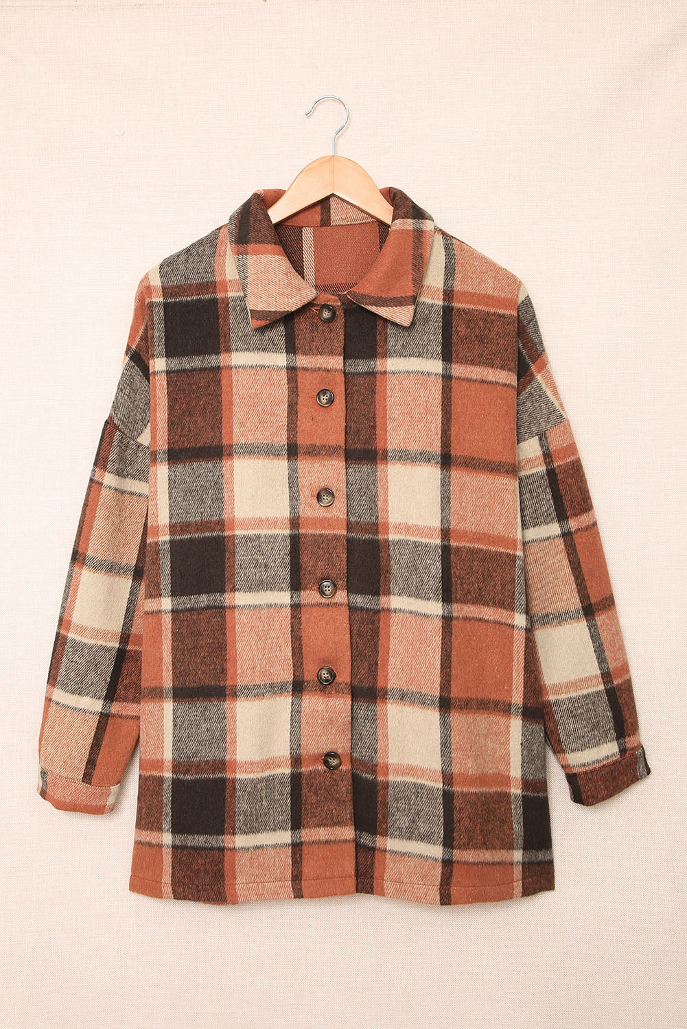 A stylish plaid print buttoned shirt jacket in warm tones, showcasing its soft fabric and button closure design.