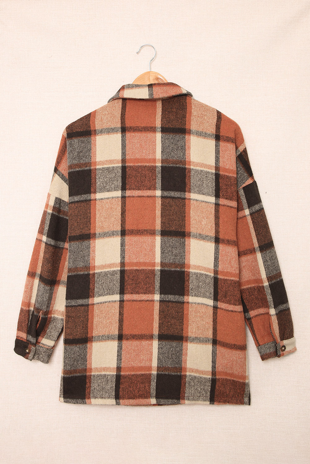 A stylish plaid print buttoned shirt jacket in warm tones, showcasing its soft fabric and button closure design.