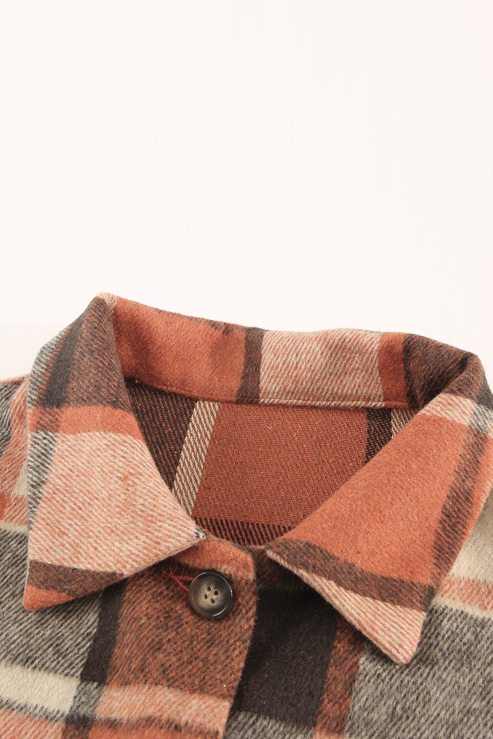 A stylish plaid print buttoned shirt jacket in warm tones, showcasing its soft fabric and button closure design.