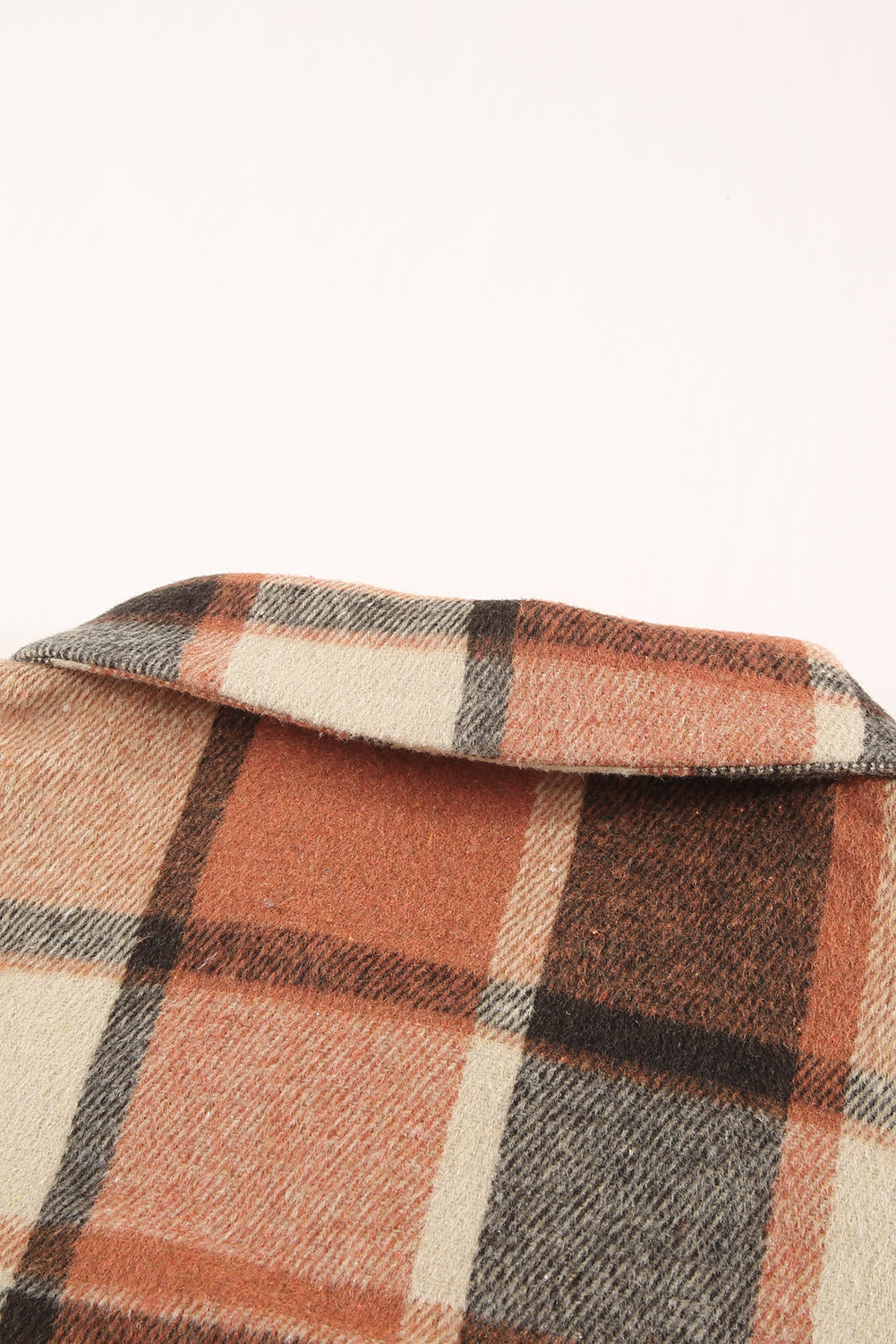 A stylish plaid print buttoned shirt jacket in warm tones, showcasing its soft fabric and button closure design.