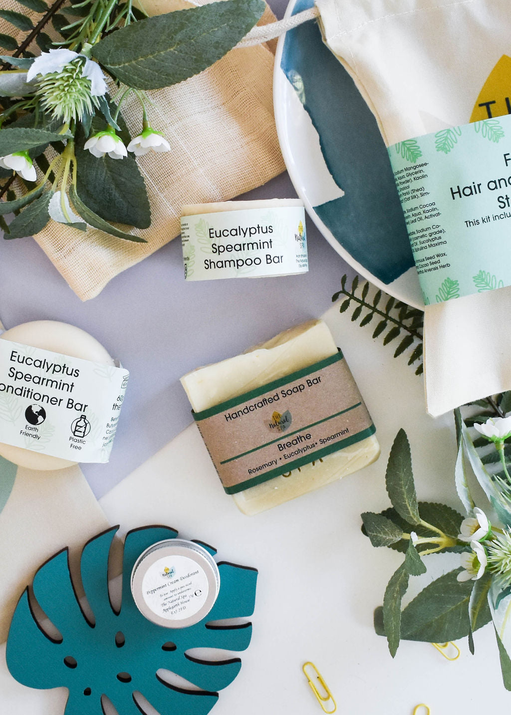 Plastic Free Hair and Body Wash Starter Kit featuring soap, shampoo, conditioner bars, bamboo washcloth, and recycled travel bag.