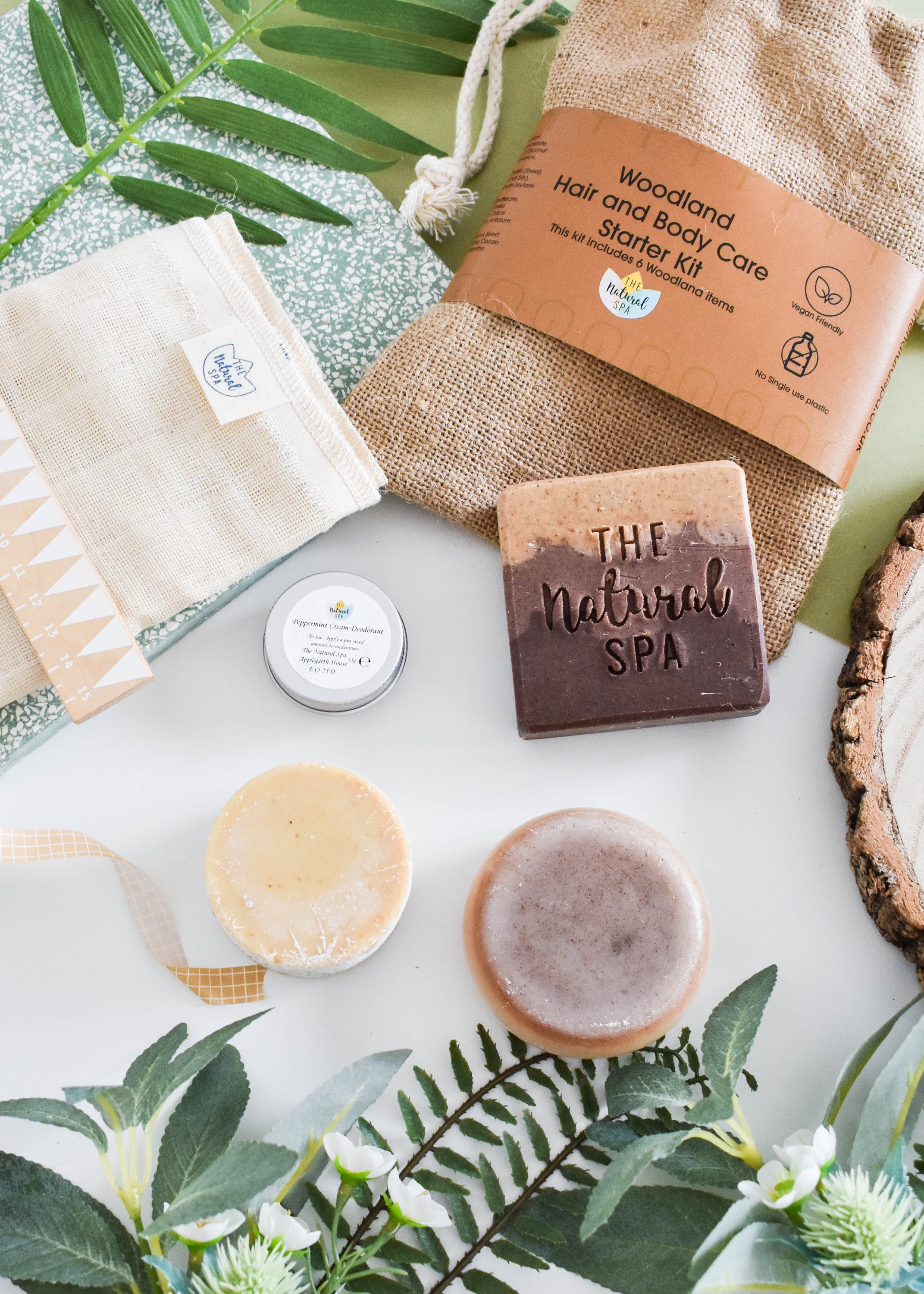 Plastic Free Hair and Body Wash Starter Kit featuring soap, shampoo, conditioner bars, bamboo washcloth, and recycled travel bag.