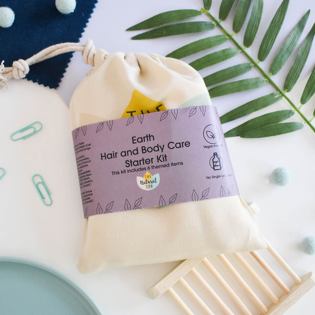 Plastic Free Hair and Body Wash Starter Kit featuring soap, shampoo, conditioner bars, bamboo washcloth, and recycled travel bag.