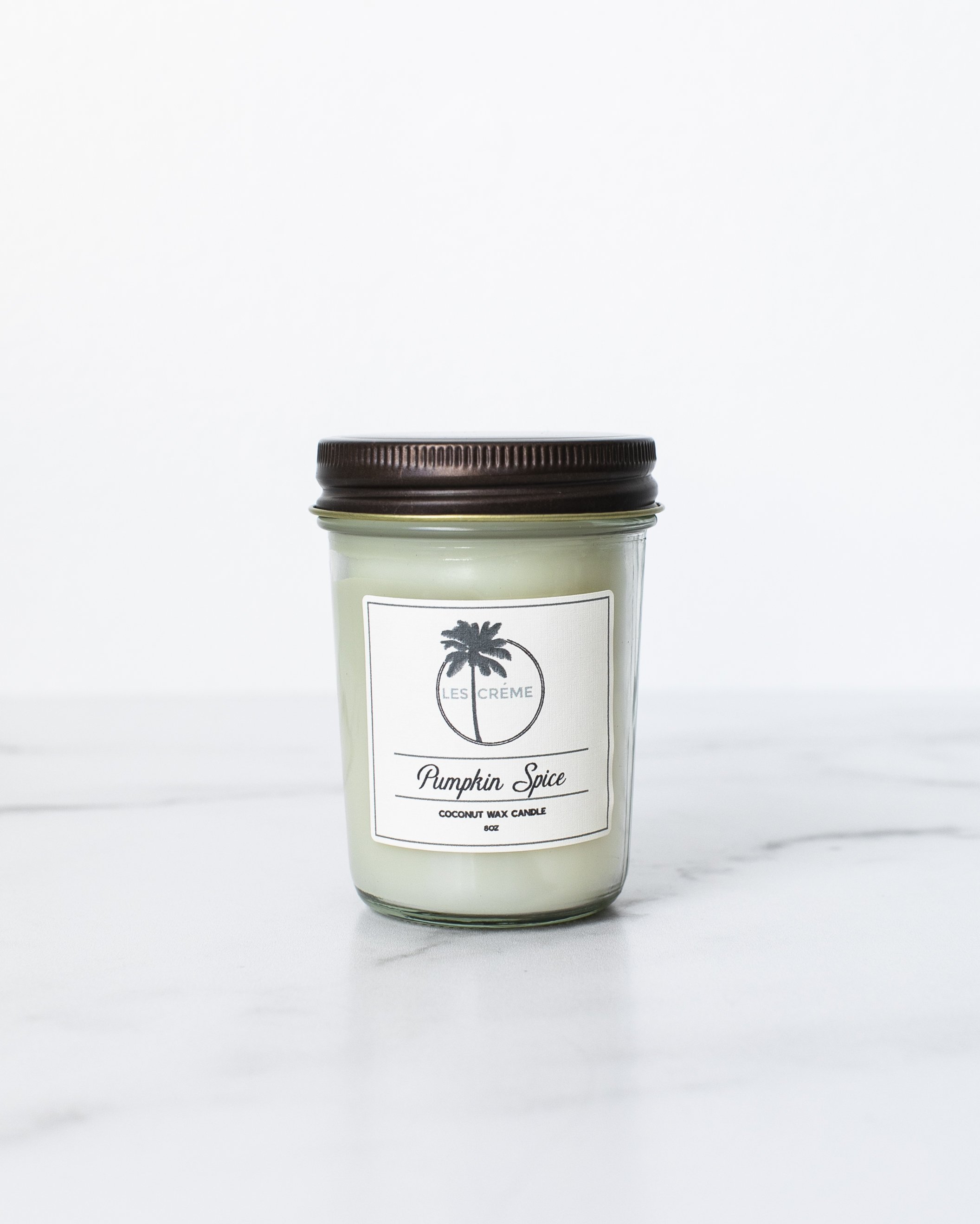 A beautifully crafted Pumpkin Spice Scent Coconut Wax Candle in a glass jar, showcasing its warm, inviting color and natural cotton wick.