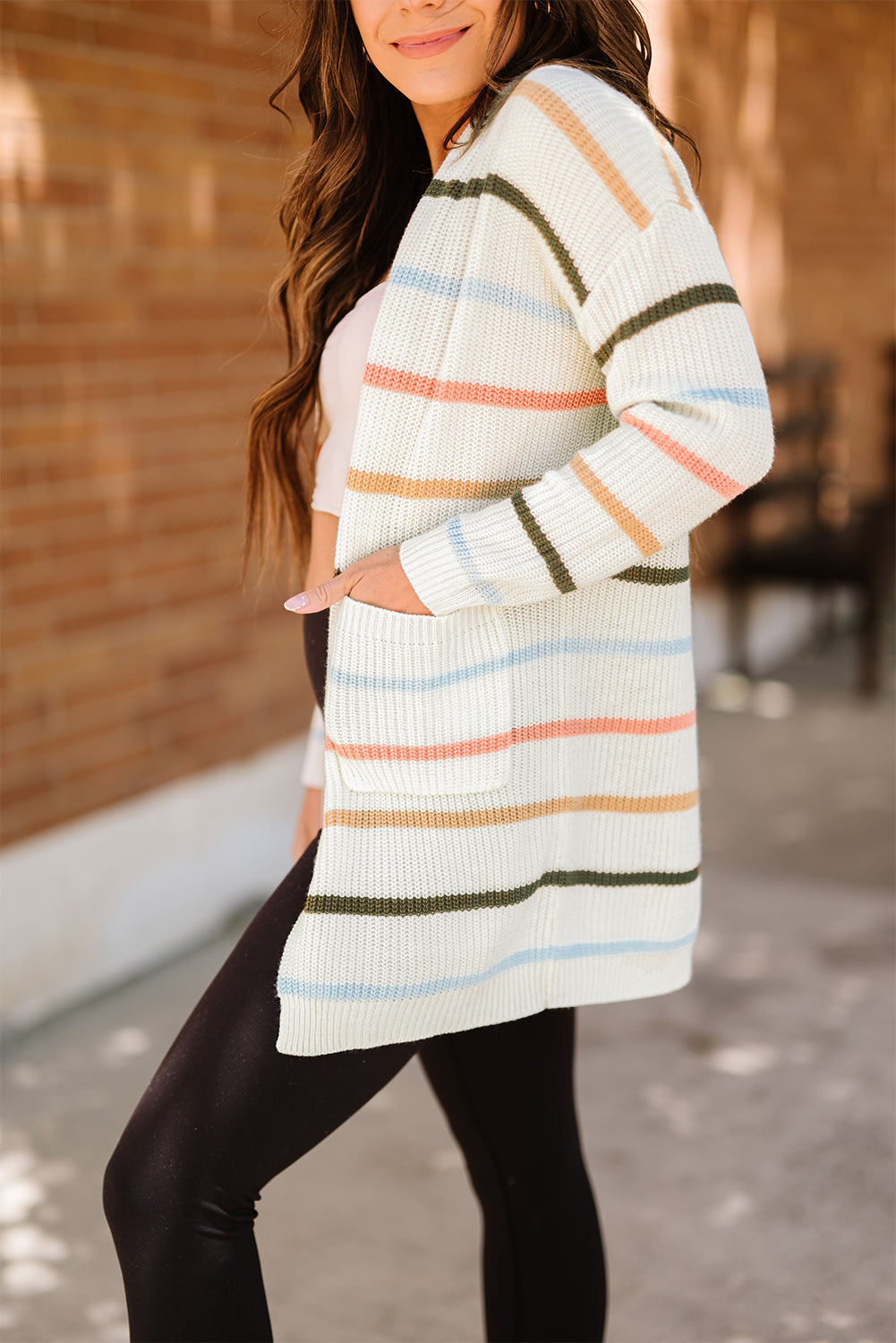 A cozy Rainbow Striped Cardigan featuring vibrant colors and a soft texture, perfect for layering in any season.