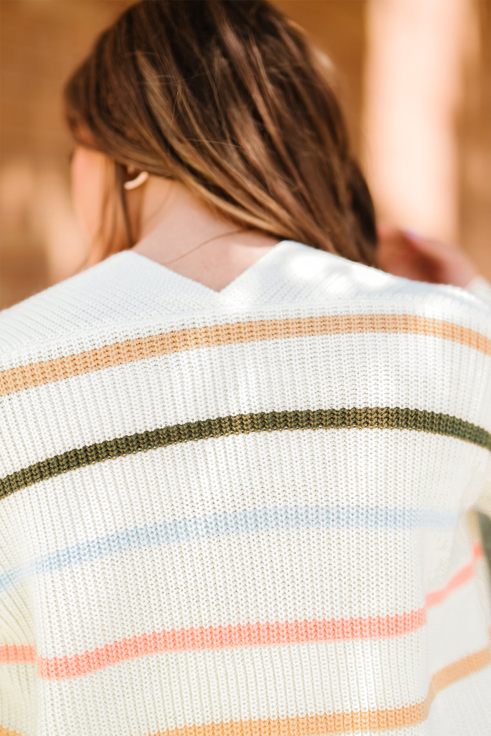 A cozy Rainbow Striped Cardigan featuring vibrant colors and a soft texture, perfect for layering in any season.