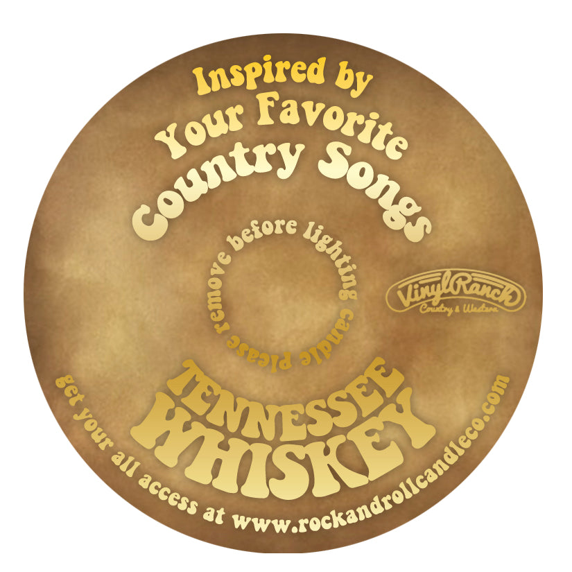 R&RCCo x Vinyl Ranch Tennessee Whiskey candle with a warm glow, featuring a label that highlights its bourbon, honey, and vanilla scent notes.