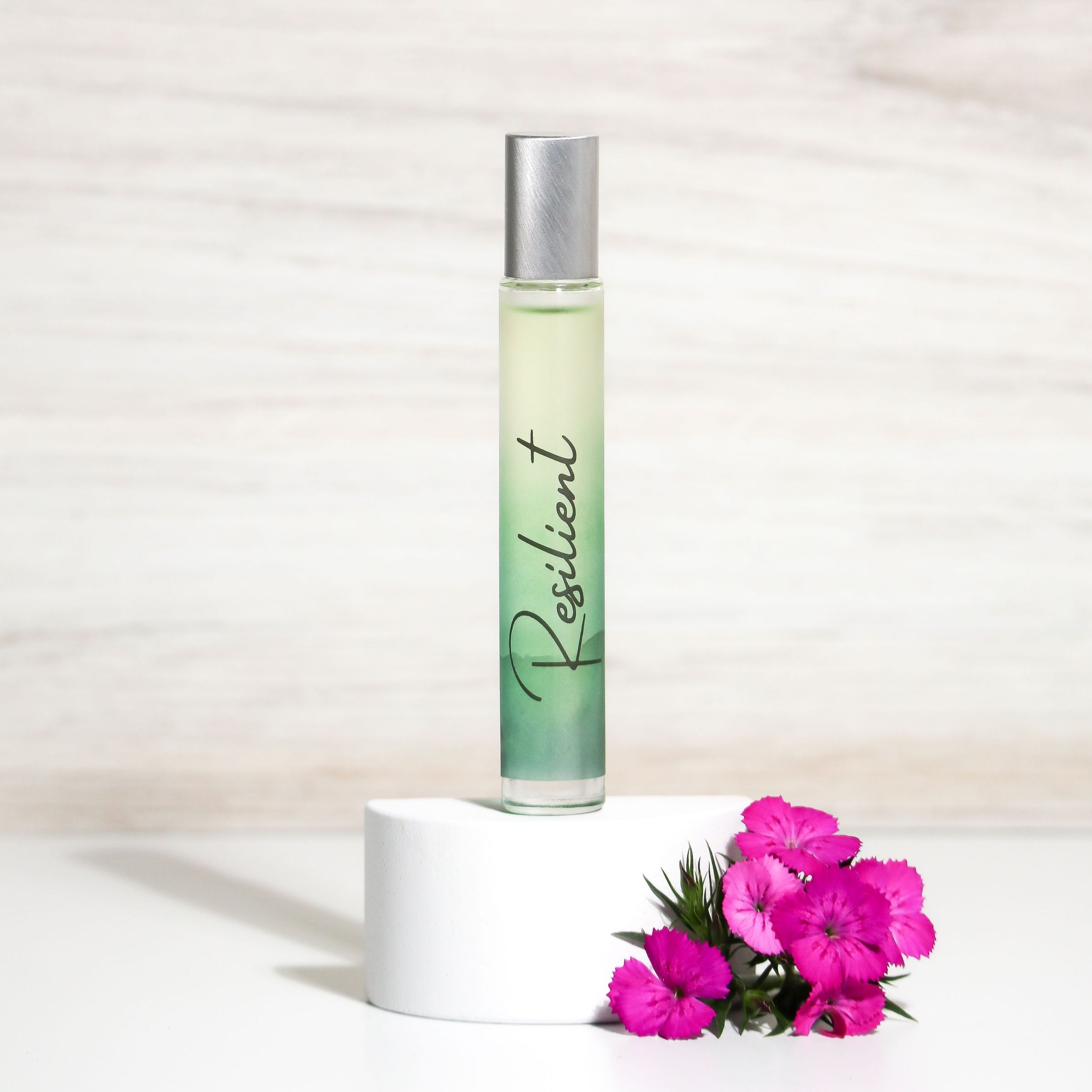 Resilient Rollerball Perfume in a stylish bottle, showcasing its floral and woody fragrance notes, perfect for empowering women.