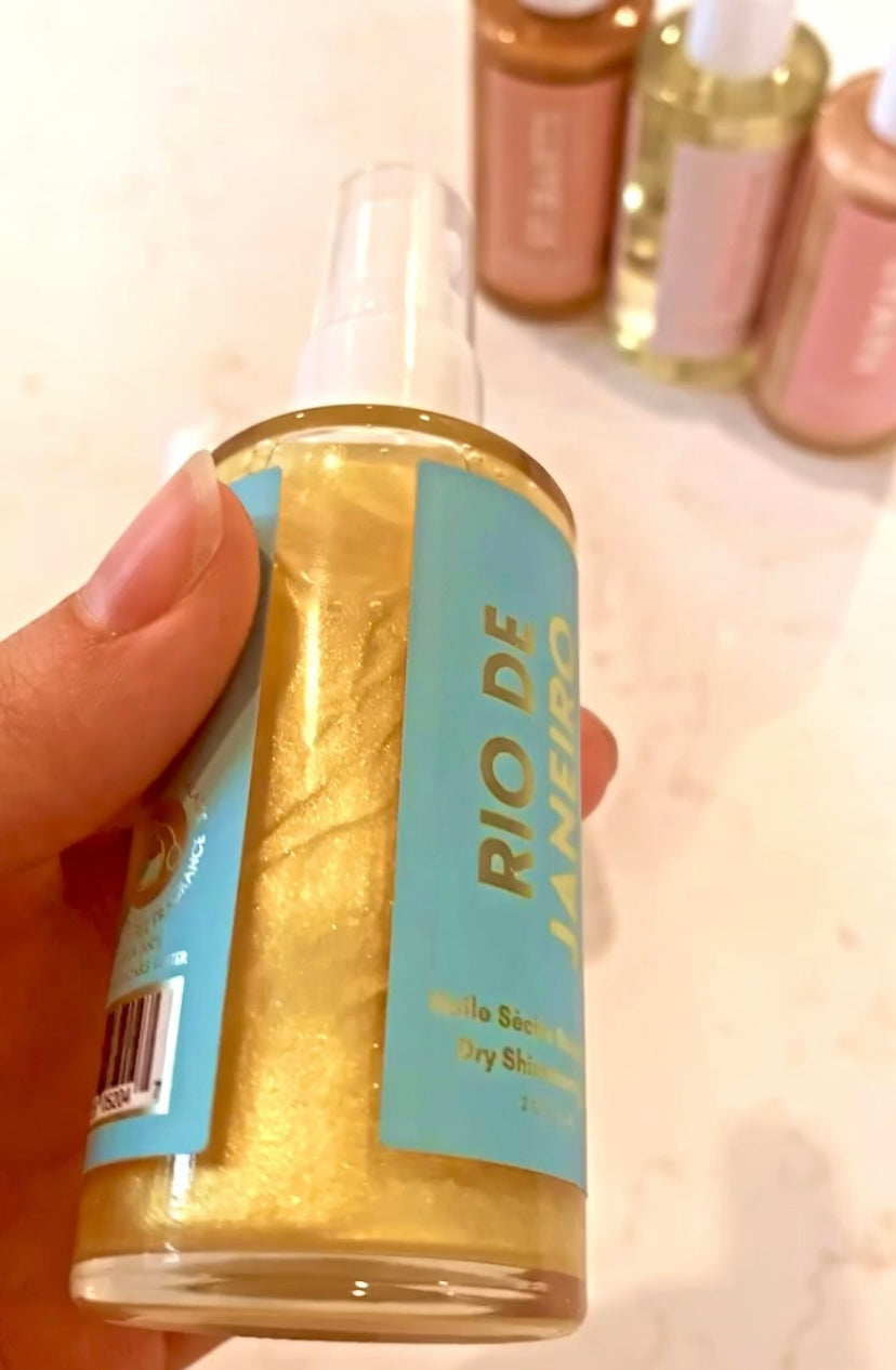 Bottle of Rio De Janeiro Dry Shimmering Oil with a shimmering golden hue, showcasing its tropical scent and organic ingredients.