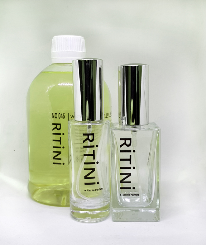 RiTiNi woman 054 - Insolence Eau de Parfum 500 ml refill bottle with two empty perfume bottles, showcasing a floral and powdery scent.