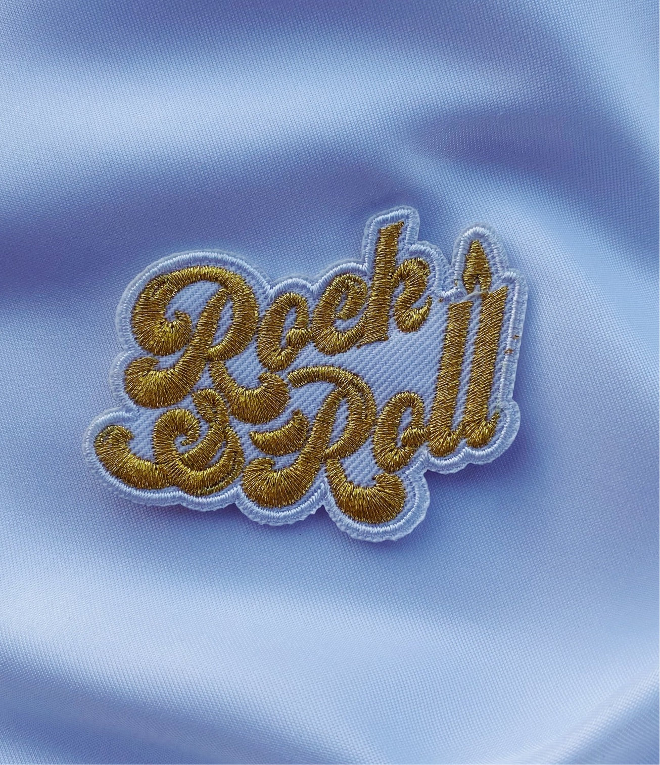 A vibrant 'Rock & Roll' iron-on patch featuring metallic gold thread on a black background, measuring 2.5 inches.