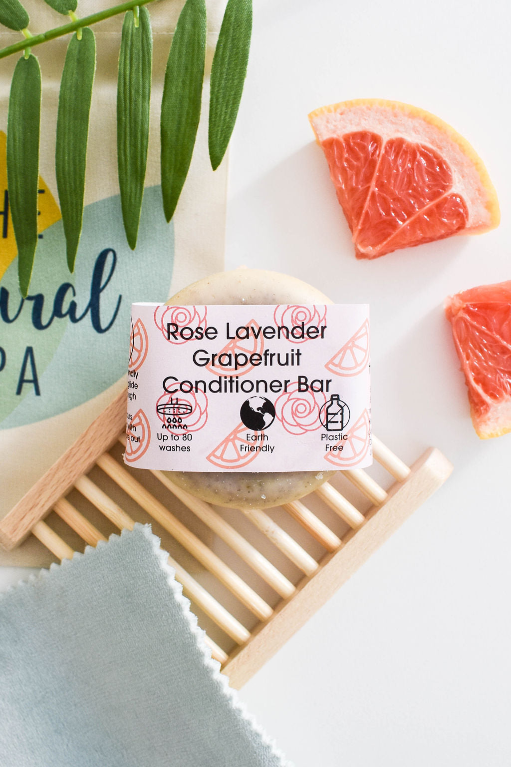 A beautifully crafted solid conditioner bar featuring rose, grapefruit, and lavender scents, showcasing its unique design and eco-friendly packaging.