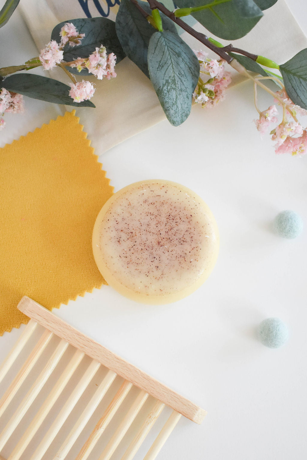 A beautifully crafted solid conditioner bar featuring rose, grapefruit, and lavender scents, showcasing its unique design and eco-friendly packaging.