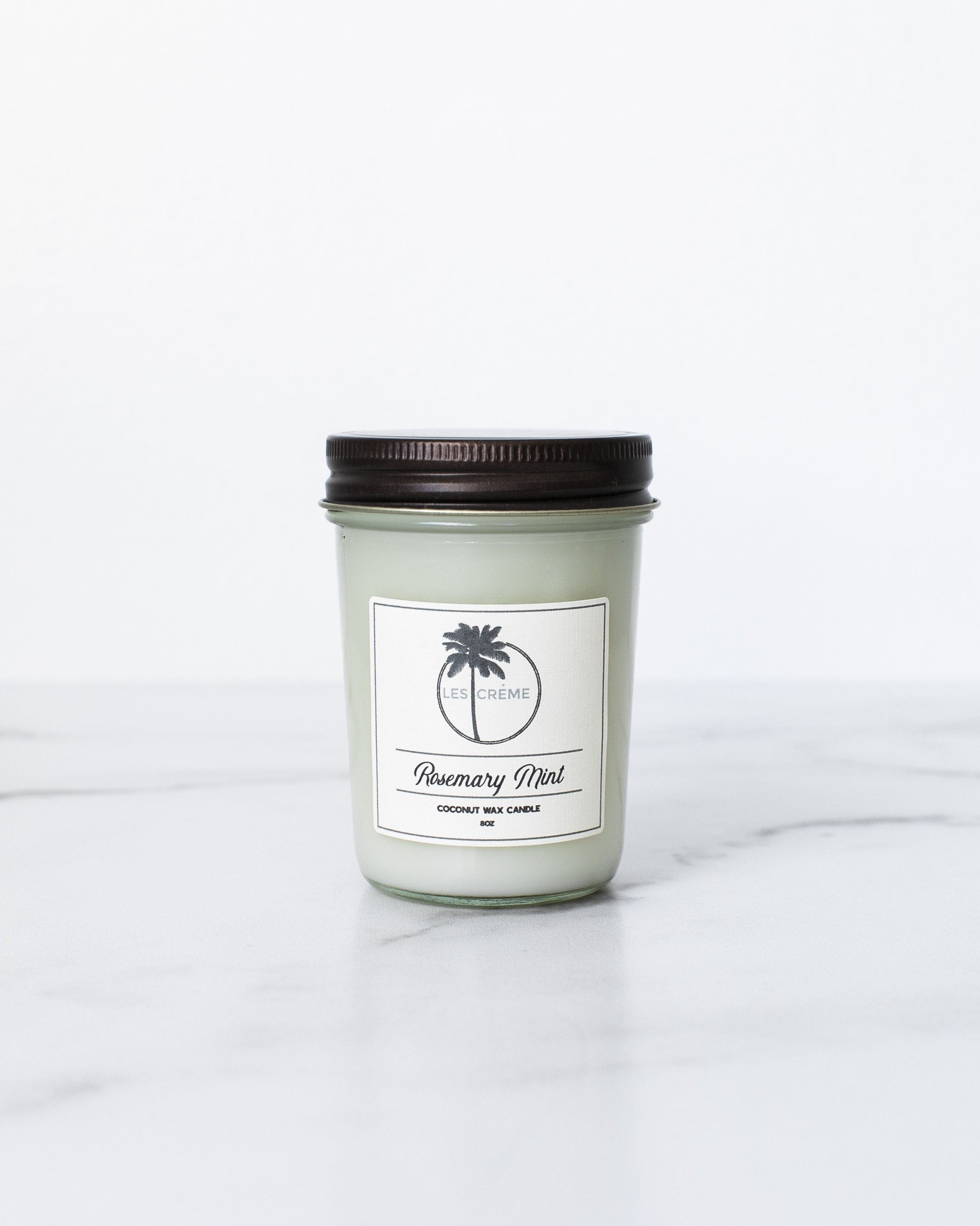 Rosemary Mint Scent Coconut Wax Candle in a stylish glass jar, showcasing its natural ingredients and inviting aroma.