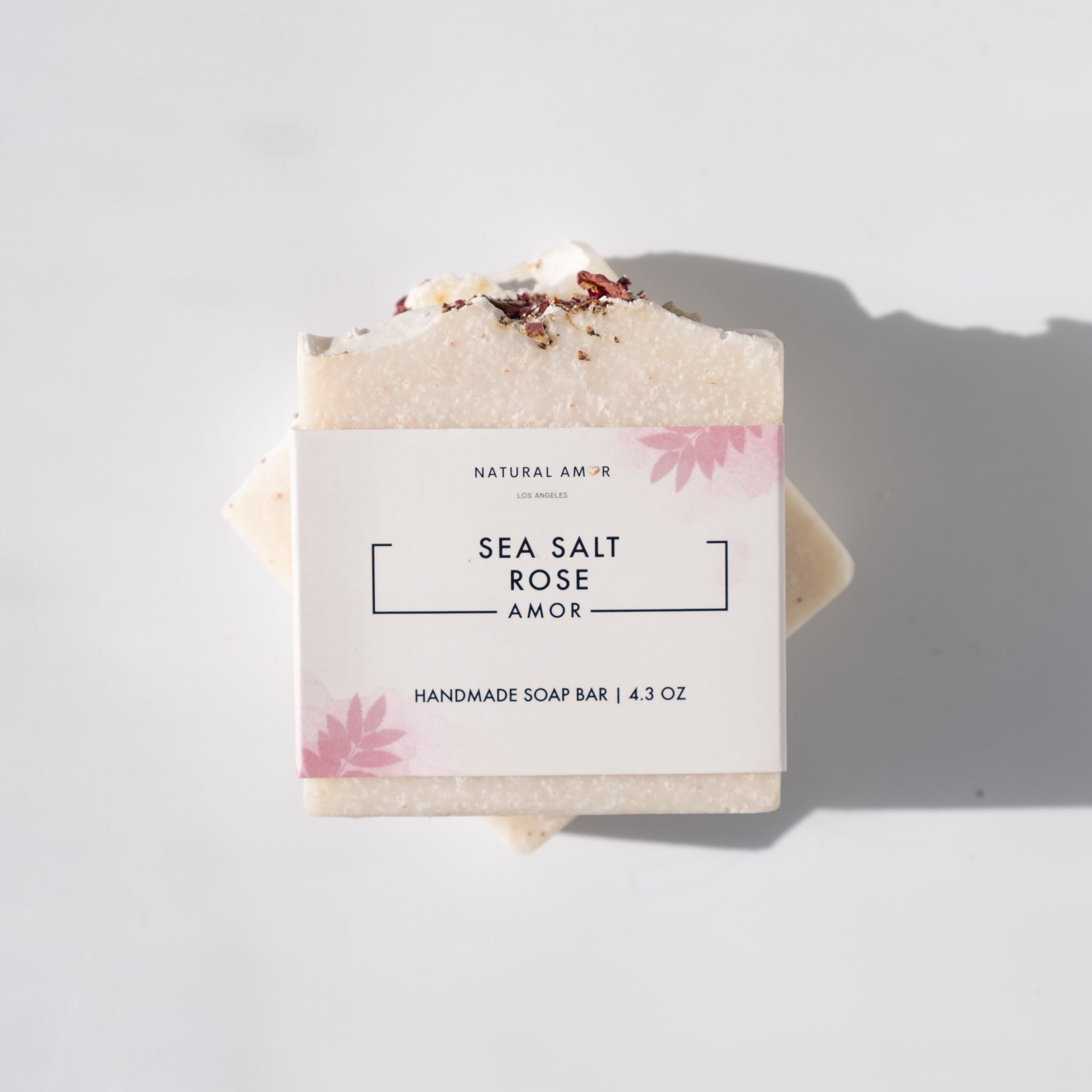 A beautifully crafted Sea Salt Rose Soap Bar with pink hues, showcasing rose petals and a smooth texture, perfect for exfoliating and nourishing the skin.