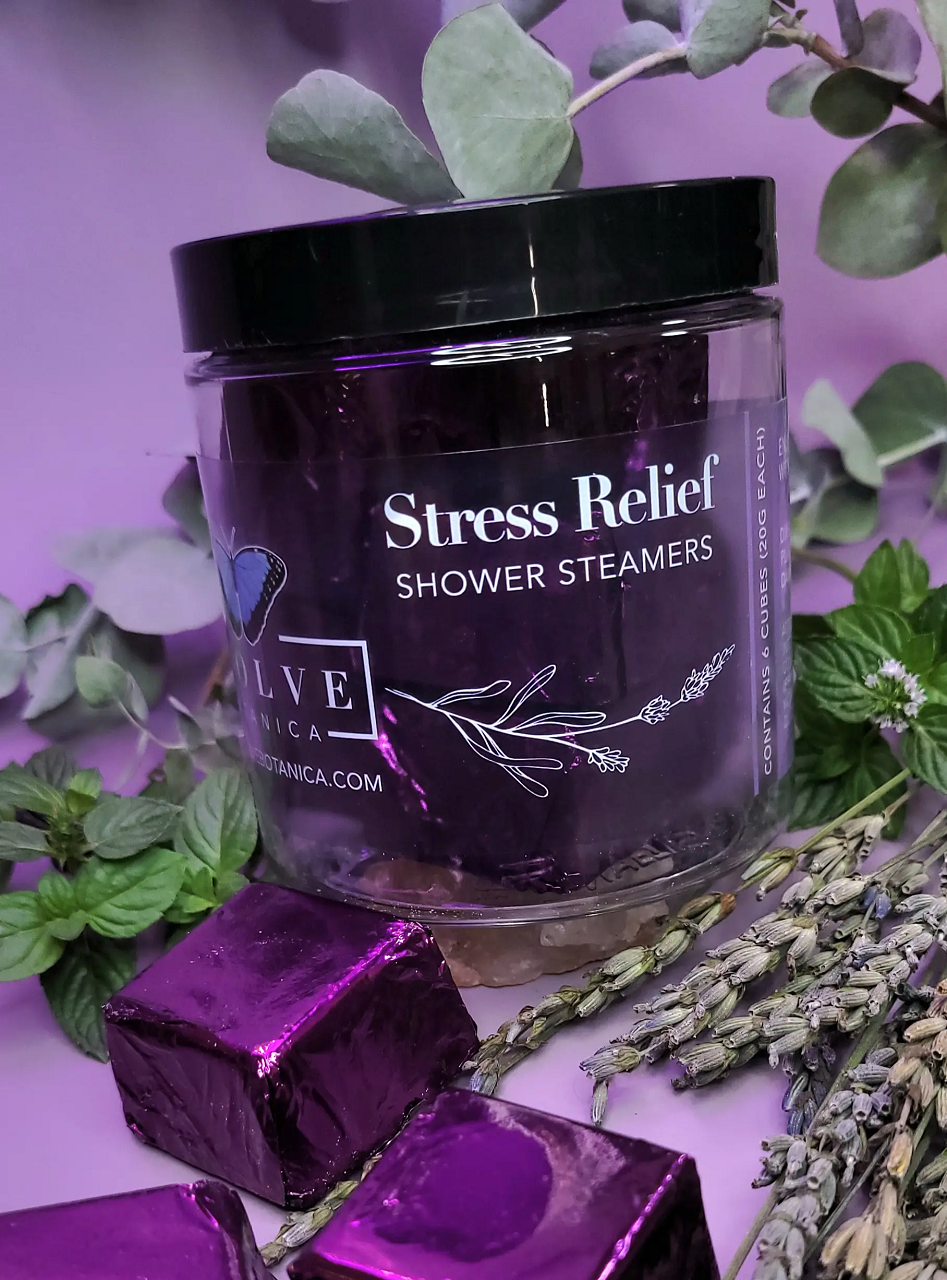 A package of six all-natural shower steamers for stress relief, featuring lavender, peppermint, and eucalyptus essential oils, displayed on a bathroom counter.