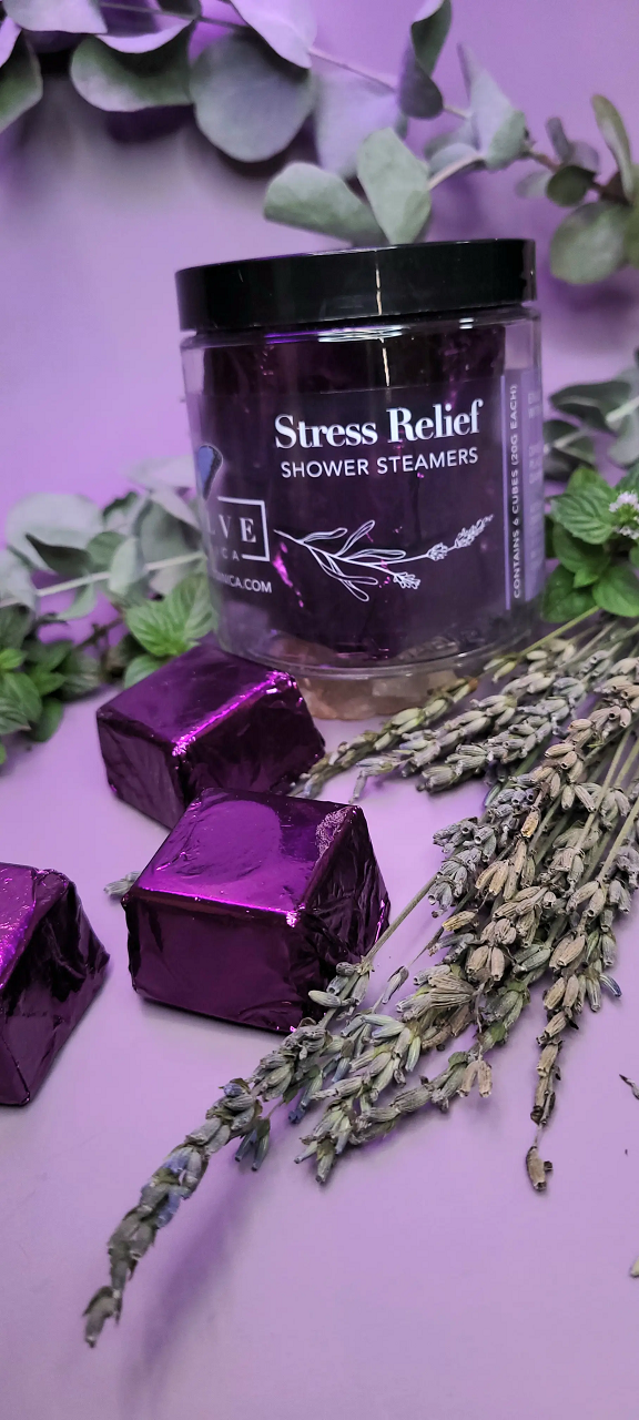 A package of six all-natural shower steamers for stress relief, featuring lavender, peppermint, and eucalyptus essential oils, displayed on a bathroom counter.