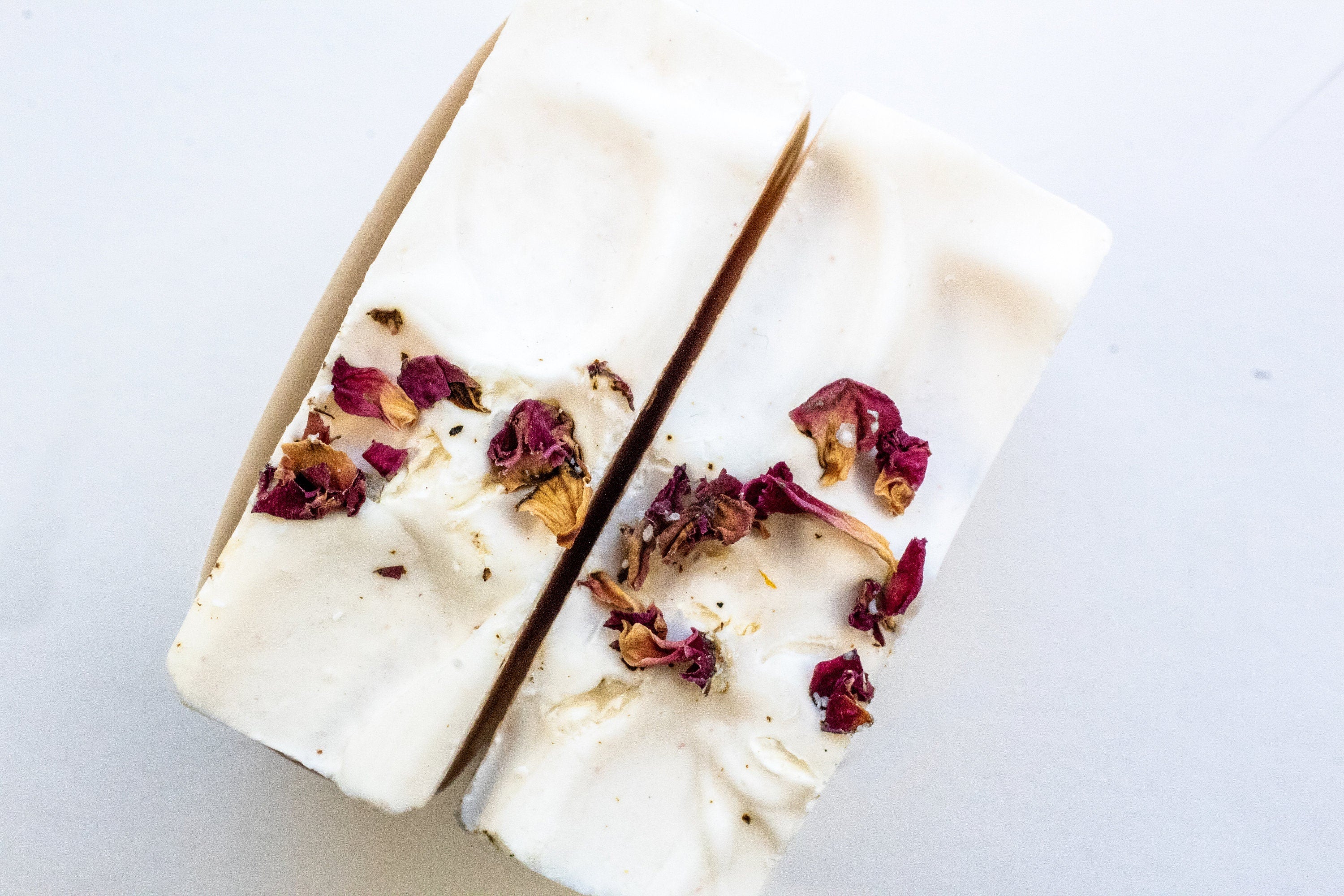 A beautifully arranged Simple Care Package Gift Box featuring a wooden soap dish, soap saver, and assorted handmade soaps in a printed gift box.