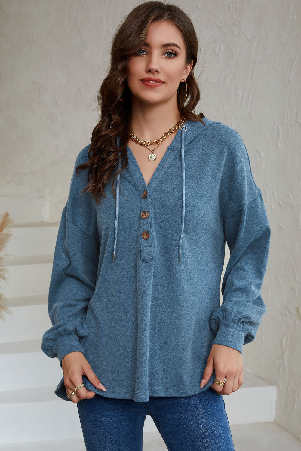 Sky Blue Buttoned High and Low Hem Hoodie with drawstring hood and tortoiseshell buttons, showcasing a relaxed fit and side slits.